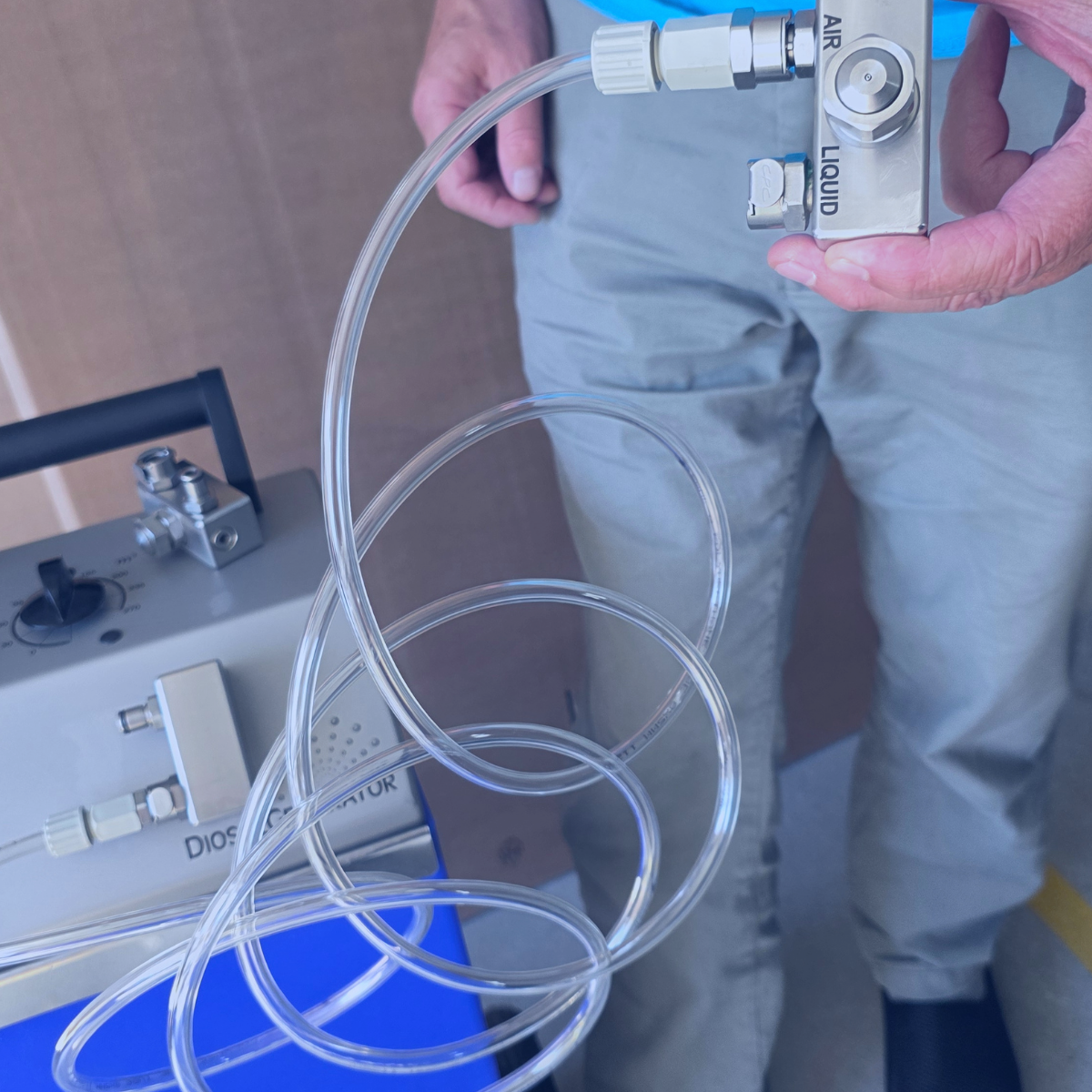 Anschlüsse und Schläuche eines DiosolGenerators Techniker hält die Anschlüsse und Schläuche eines DiosolGenerators für die professionelle H₂O₂-Raumdesinfektion mit Wasserstoffperoxid.